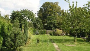 A well-maintained garden with a stone pathway leading to a wooden structure.