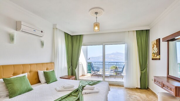 Une chambre d’hôtel avec deux lits, un balcon avec vue et une grande fenêtre.