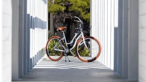 Un vélo est garé dans une structure blanche, de forme géométrique, qui ressemble à un tunnel.