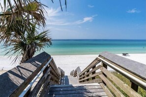 A wooden staircase leading to a beach with a palm tree on the left and a clear blue sky. - Olive's Cottage in The Hammocks / 2 Pools / Short Walk to Beach / 4 Bikes (Seagrove Beach)