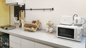 A kitchen with a microwave, kettle, and various utensils. - Cheese Guesthouse - Hostel (Seoul)