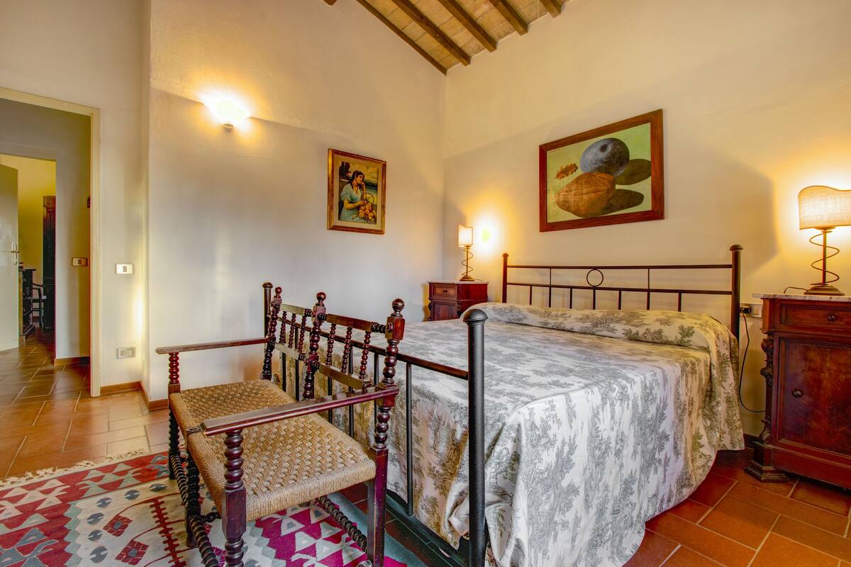 Une chambre à coucher avec un lit à baldaquin en bois, une table de chevet, une chaise et un tapis.