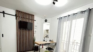 A modern living room with a sofa, coffee table, and a TV mounted on the wall. - Athens Studio in the sky...❗️❗️❗️ perfect for couples❤️️ (Kallithea)