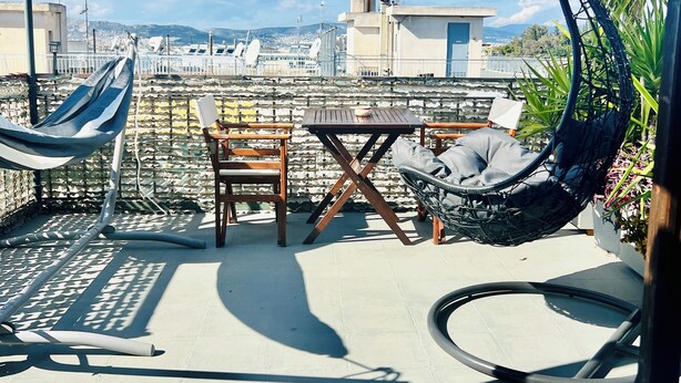 A rooftop terrace with a table and chairs, a hanging chair, and a canopy. - Athens Studio in the sky...❗️❗️❗️ perfect for couples❤️️ (Kallithea)
