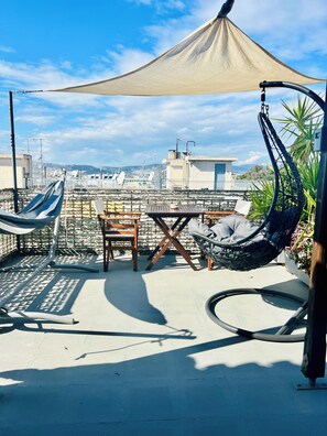 A rooftop terrace with a table and chairs, a hanging chair, and a canopy. - Athens Studio in the sky...❗️❗️❗️ perfect for couples❤️️ (Kallithea)