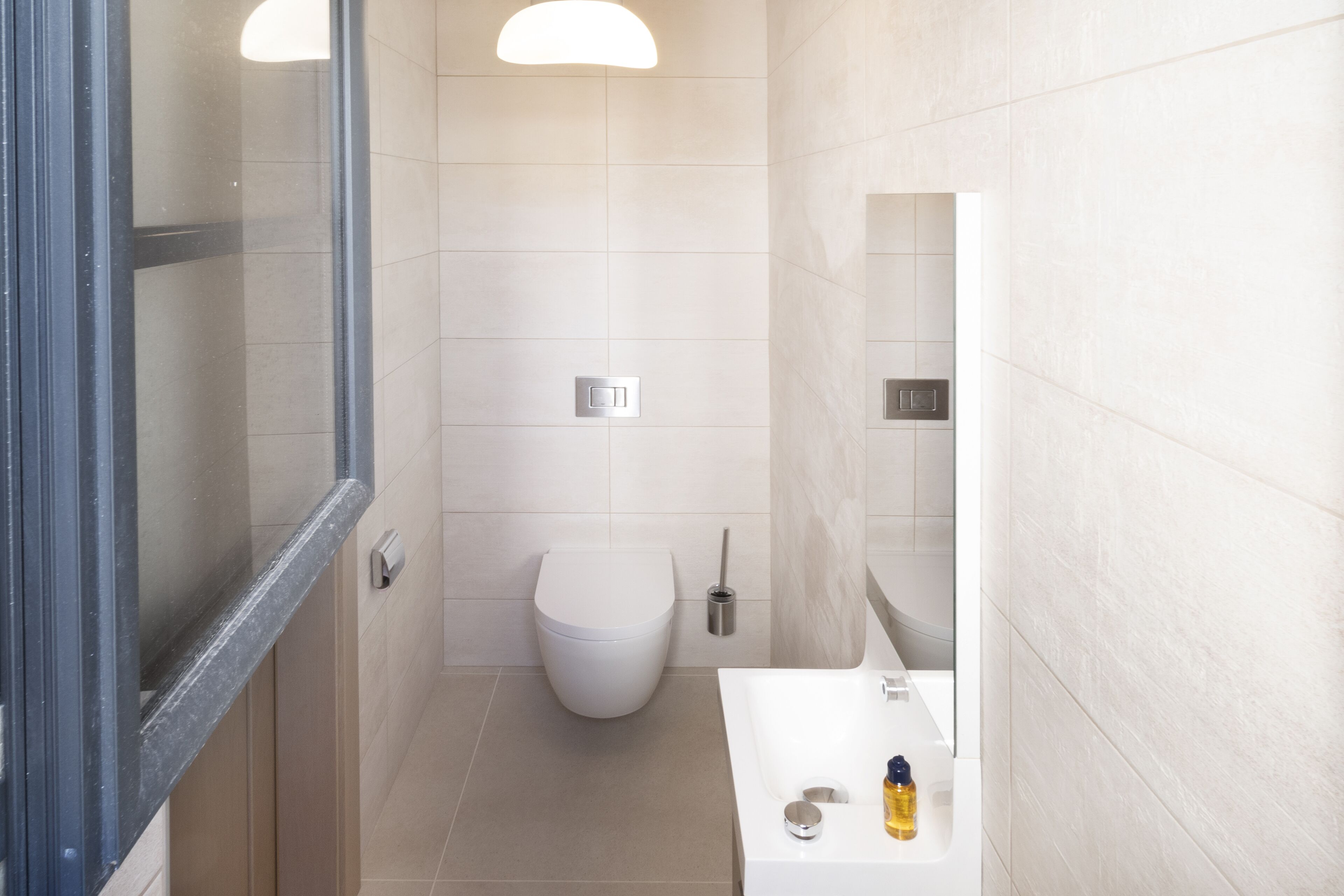 Une salle de bain comprenant des toilettes, un lavabo et un espace douche.