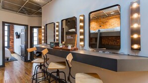 Un espace bar moderne, doté d’un long comptoir, de nombreux miroirs et de tabourets de bar.
