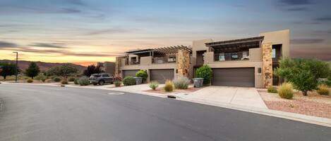 A modern two-story house with a garage, a driveway, and a landscaped front yard.