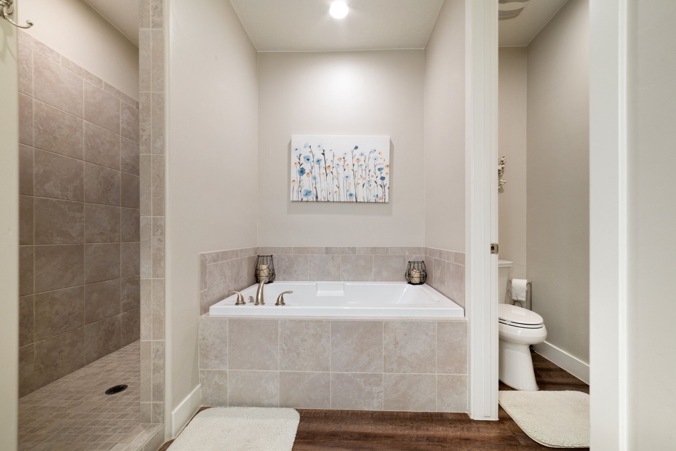 A modern bathroom with a bathtub, shower, and toilet.