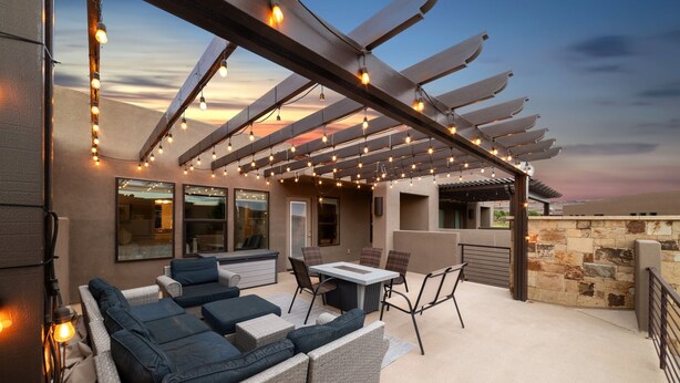 An outdoor patio with a pergola, seating, and a stone wall. - Sleeps 16 w/ 4 Kings - Bunk Loft on the 18th Hole (St. George)