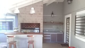 Cozinha moderna com ilha central, banquetas e fogão a gás.