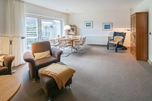 TV, fireplace, books - Cozy semi-detached house with fireplace and beautiful garden to relax. (Carolinensiel)