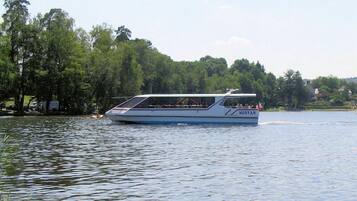 A boat named 'MORVAN' on a lake with trees and houses in the background.