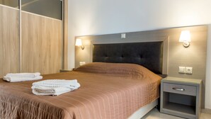 Ett modernt hotellrum med en stor säng, två sängbord och en garderob.