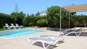 A swimming pool with lounge chairs and a pergola. - Vacation home close to the beach with private pool. Quiet location. 5min to Sa Coma beach. (Sa Coma)