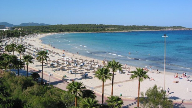A beach with palm trees, umbrellas, and a clear blue sky. - Vacation home close to the beach with private pool. Quiet location. 5min to Sa Coma beach. (Sa Coma)