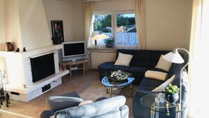 Un salon avec une cheminée, un téléviseur, un canapé et une table basse.
