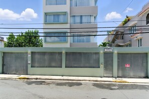 Un bâtiment doté d’une grille métallique fermée, d’un panneau indiquant « Interdiction de stationner » et d’un autre panneau indiquant « Villa 154 » ainsi qu’une adresse de site web.