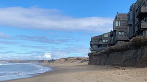 Un bâtiment situé sur la côte, doté de nombreux balcons qui donnent sur la plage.