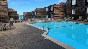 Une piscine avec des chaises longues et vue sur l’océan.