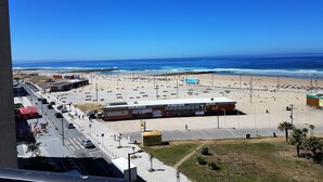 A beachside view with a parking lot, a restaurant, and a view of the ocean.