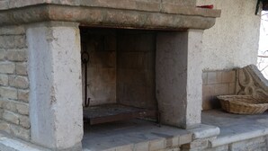 A stone-built outdoor oven with a brick base, a wooden door, and a basket on the right. - Roccascalegna, Chieti (Roccascalegna)