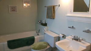 A bathroom with a bathtub, toilet, and sink. - Beautiful 1921 brick and fieldstone Country Country ... The Tummel house (Roblin)
