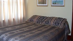 A bedroom with a bed, two framed pictures on the wall, and a window with curtains. - Beautiful 1921 brick and fieldstone Country Country ... The Tummel house (Roblin)
