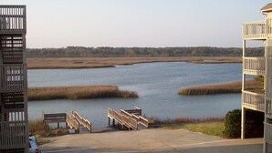 Un espace de stationnement offrant une vue sur un lac et les marais environnants.