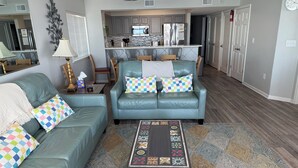 A living room with a sofa, coffee table, and patterned rug. - 4BR Oceanfront Condo in Myrtle Beach  (North Myrtle Beach)