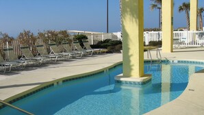A pool area with lounge chairs and a lifeguard station. - 4BR Oceanfront Condo in Myrtle Beach  (North Myrtle Beach)
