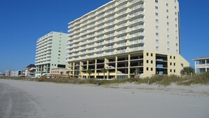 A multi-story hotel with balconies, a parking garage, and a beach view. - 4BR Oceanfront Condo in Myrtle Beach  (North Myrtle Beach)