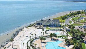 A resort with a large pool, beach access, and a building with a curved roof. - PRISTINE BEACH, GOLF, TENNIS!  BEAUTIFUL AND SPACIOUS 2BR COURTSIDE VILLA!  (Seabrook Island)