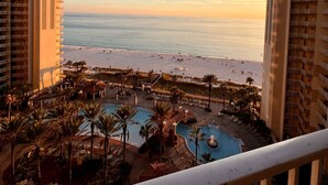 A resort with a pool area, beach access, and a view of the ocean.