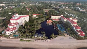 A resort with multiple buildings, a swimming pool, and a beach area. - Beachfront condo with full sea view and the facilities of a 5-star resort (Petchaburi)