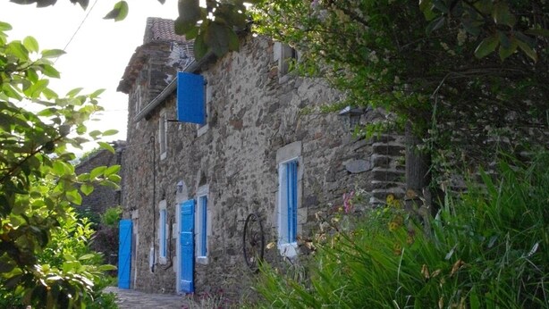 A narrow stone pathway leading to a rustic stone building with blue shutters. - Authentic 19th century house near Vans (Malons-Et-Elze)
