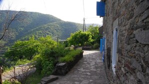 A stone pathway leading to a rustic building with a view of a green hillside. - Authentic 19th century house near Vans (Malons-Et-Elze)