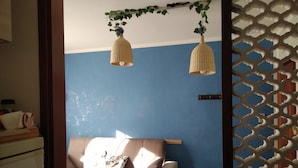 A room with a blue wall, a white sofa with cushions, and two wicker pendant lights. - Pretty Casa Margherita, Lugana di Sirmione for your relaxation (Sirmione)