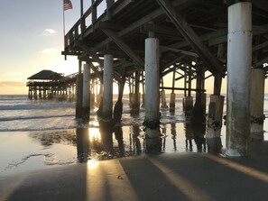 A pier with a wooden structure and concrete pillars extending into the water. - Beachfront 2BR Townhouse Ocean-View Balcony, Pool & Private Beach (Cocoa Beach)