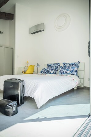 Relax in a serene space with a large bed, bedside table, and comfortable chair.