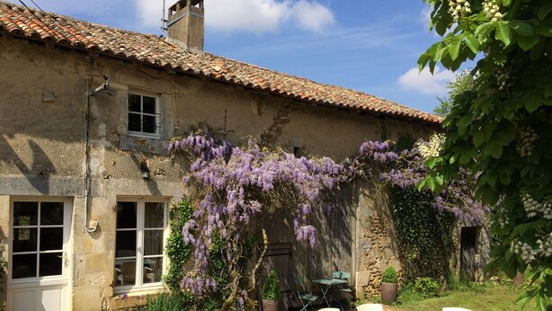 A rustic stone building with a tiled roof, a gravel patio, and white outdoor furniture. - Nature, Peace and Authenticity... (Montalembert)