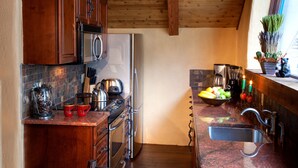 Una cucina con mobili in legno, elettrodomestici in acciaio inossidabile, un piano di lavoro in granito e una finestra con vista.