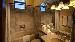 Un bagno con una vasca, un lavandino e uno specchio sopra il lavabo.