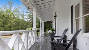 A covered porch with wooden railings and two wooden chairs. - "New" Lake Michigan R & R Recently Completed Major Rehab (Union Pier)
