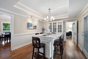 A spacious kitchen with a central island, wooden chairs, and a chandelier. - "New" Lake Michigan R & R Recently Completed Major Rehab (Union Pier)