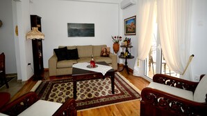 Una sala de estar con sofá, mesa de centro y alfombra estampada.