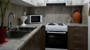 Una cocina moderna con microondas, estufa, pileta y alacenas de madera.