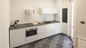 Una cucina moderna con forno integrato, lavello e un piccolo bancone.