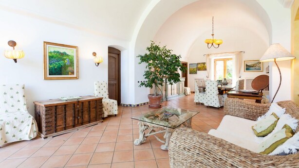 A spacious living area with a large tree, comfortable seating, and a rustic wooden chest. - Villa Polluce with private pool -My Rental Homes (Massalubrense)