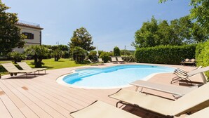 A swimming pool with lounge chairs and a building in the background. - Villa Polluce with private pool -My Rental Homes (Massalubrense)